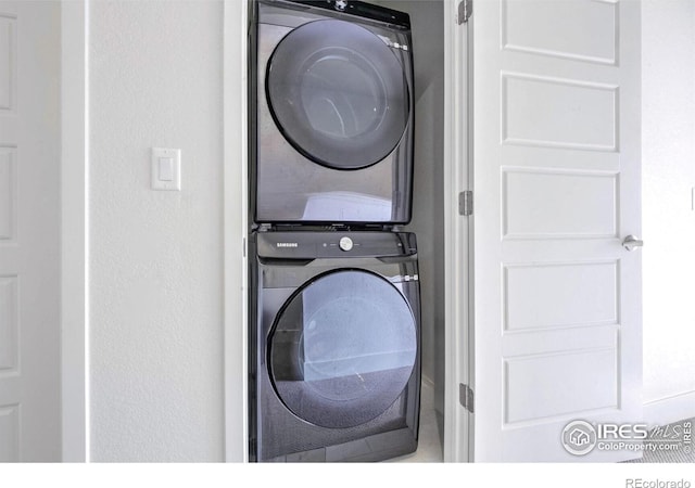 clothes washing area with stacked washer and dryer