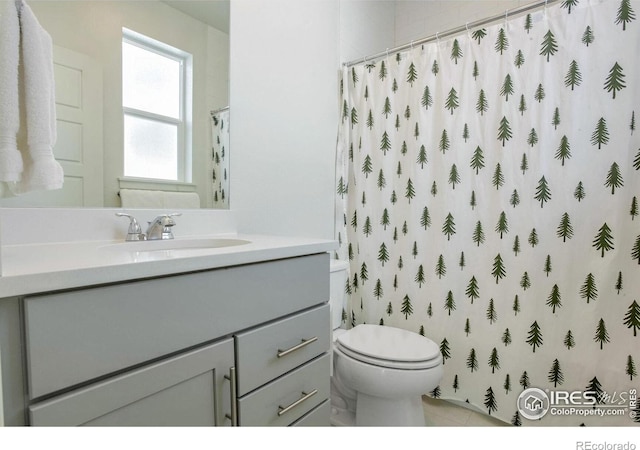 bathroom featuring vanity, curtained shower, and toilet