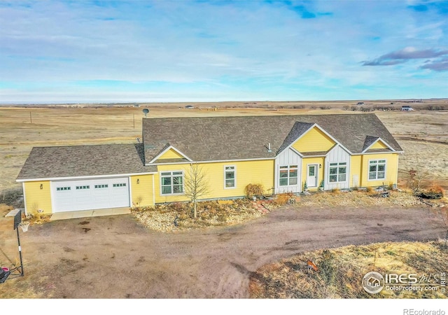 single story home featuring a rural view and a garage