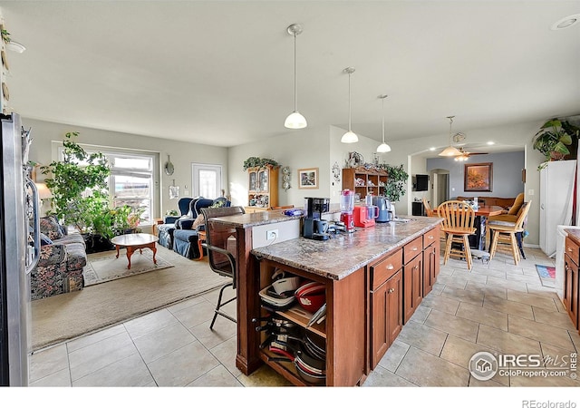 kitchen featuring light stone countertops, pendant lighting, ceiling fan, and light tile patterned flooring