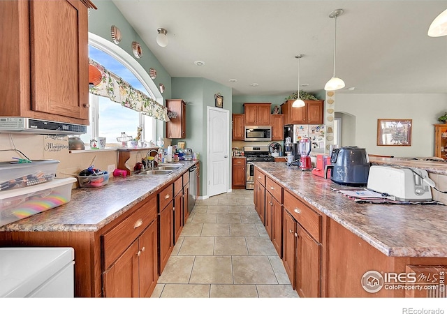 kitchen with a center island, sink, hanging light fixtures, light tile patterned floors, and stainless steel appliances