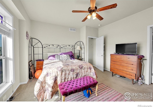 carpeted bedroom with multiple windows and ceiling fan