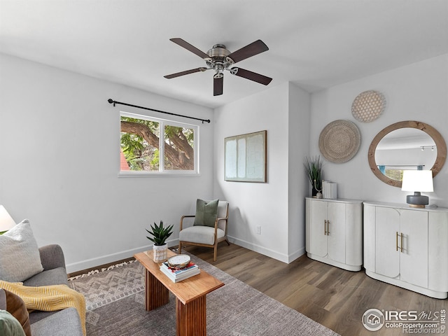 living area with ceiling fan and dark hardwood / wood-style floors