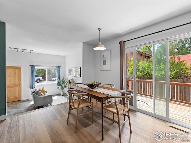 dining space featuring light wood-type flooring and rail lighting