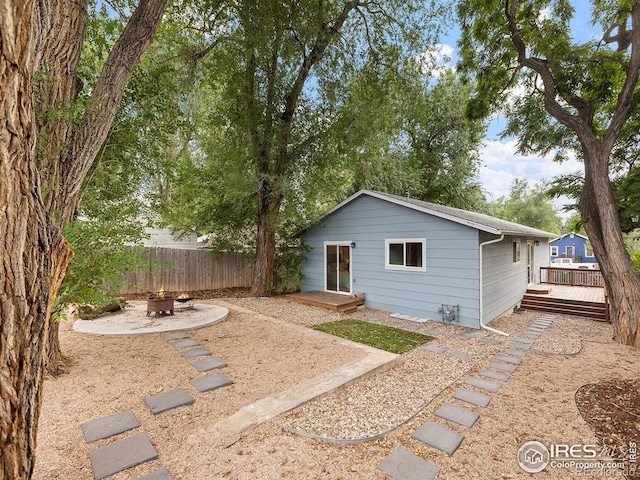 exterior space featuring a wooden deck and an outdoor fire pit