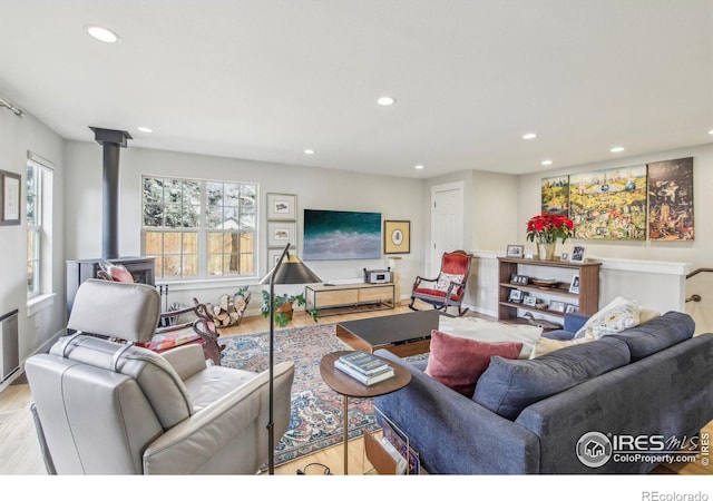 living room featuring light hardwood / wood-style flooring and a wood stove