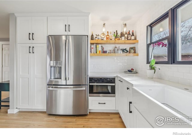 kitchen featuring light hardwood / wood-style floors, white cabinetry, and appliances with stainless steel finishes