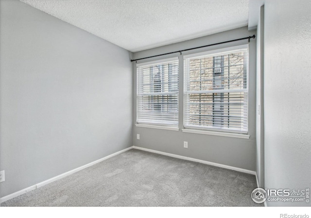 carpeted spare room featuring a textured ceiling