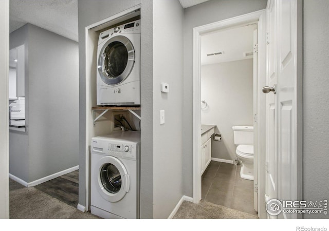 washroom with dark carpet and stacked washer / dryer