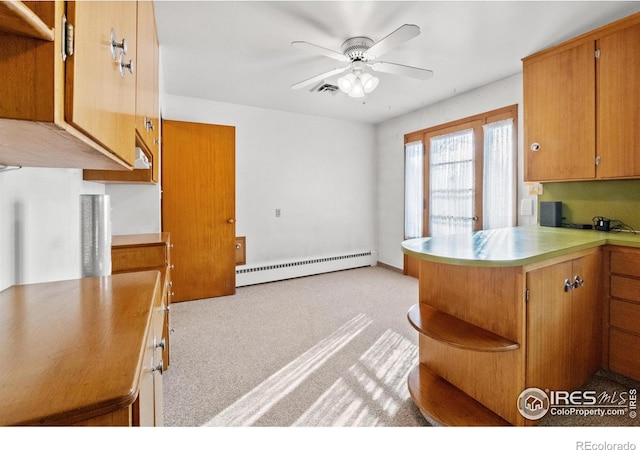 kitchen with ceiling fan, kitchen peninsula, and a baseboard radiator