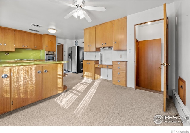 kitchen with a baseboard heating unit, ceiling fan, appliances with stainless steel finishes, light colored carpet, and kitchen peninsula