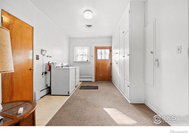 washroom featuring baseboard heating and washer and dryer