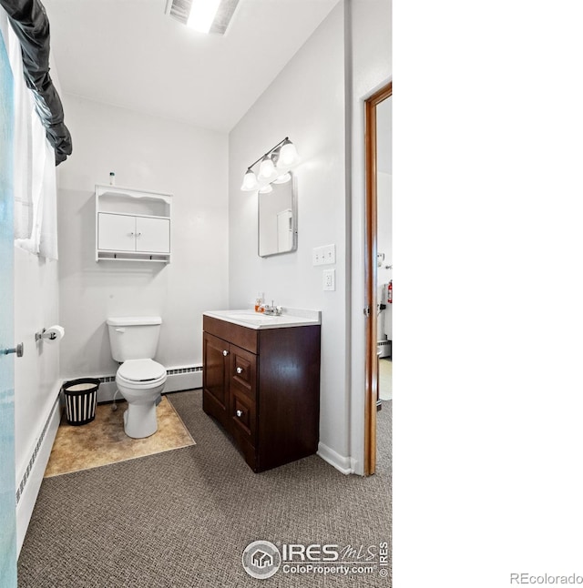 bathroom featuring tile patterned flooring, vanity, toilet, and baseboard heating