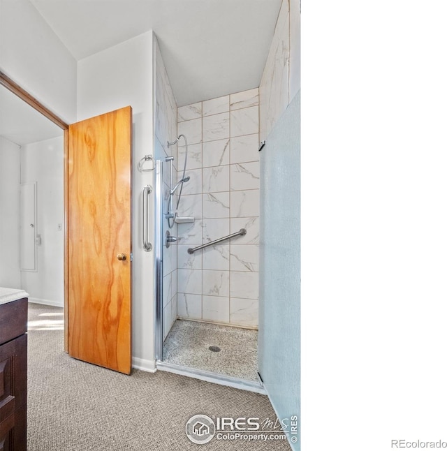 bathroom featuring a tile shower and vanity