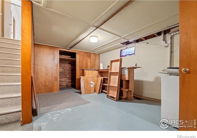 basement featuring wooden walls