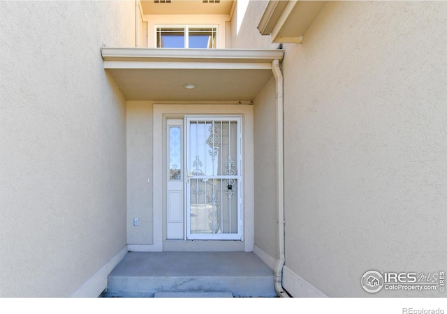 property entrance featuring stucco siding