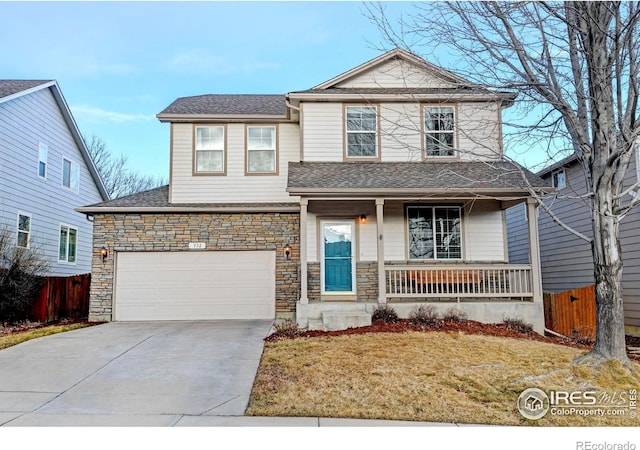 view of front property featuring covered porch, a garage, and a front yard