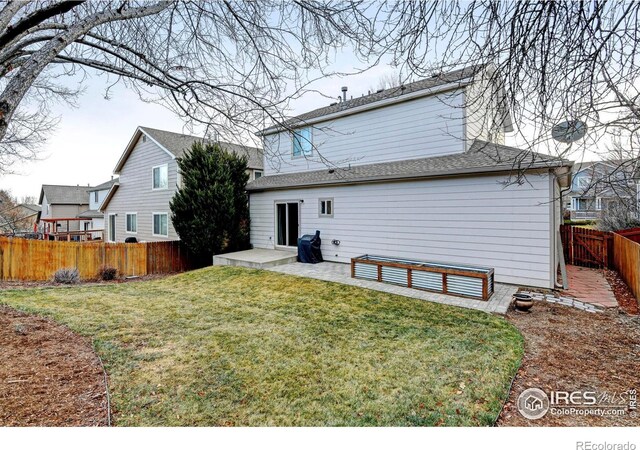 rear view of property featuring a lawn and a patio