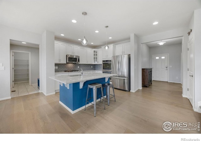 kitchen with white cabinetry, light stone countertops, decorative light fixtures, decorative backsplash, and appliances with stainless steel finishes