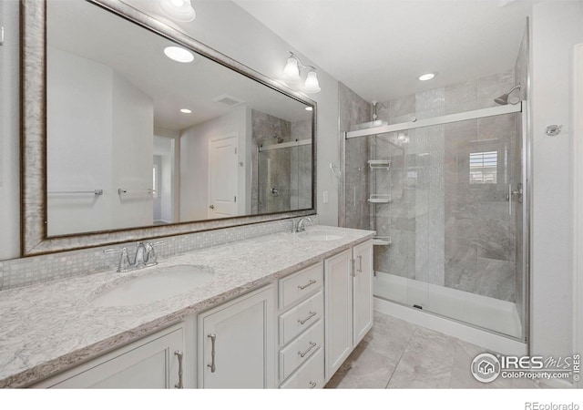 bathroom with a shower with door and vanity