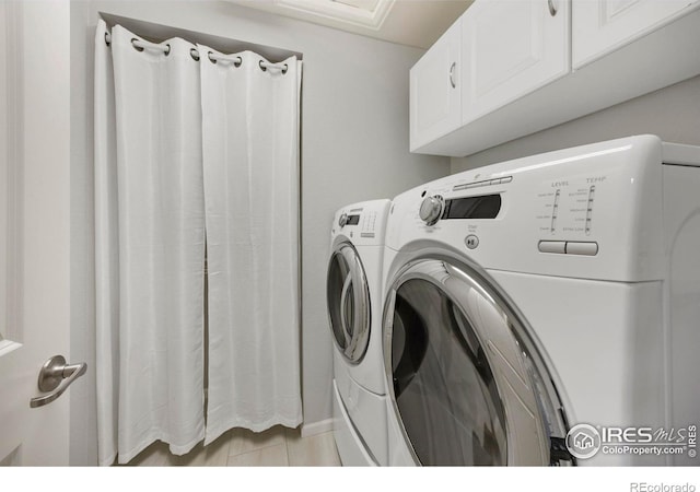 laundry area with cabinets and washing machine and clothes dryer