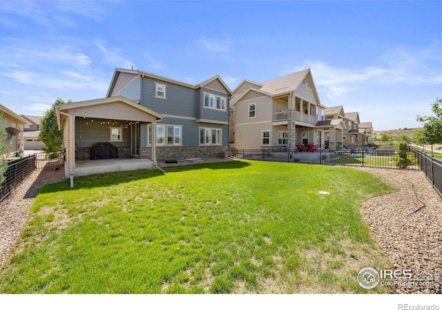 rear view of house featuring a lawn and a patio