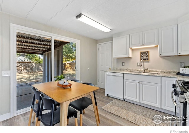 kitchen with white dishwasher, white cabinets, sink, electric range, and light stone counters