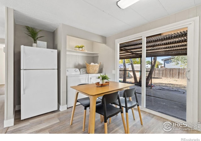 dining area featuring separate washer and dryer and light hardwood / wood-style flooring