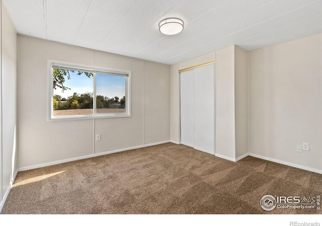 unfurnished bedroom with a closet and carpet floors