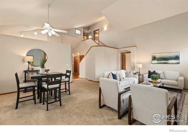 carpeted living room with ceiling fan and a towering ceiling