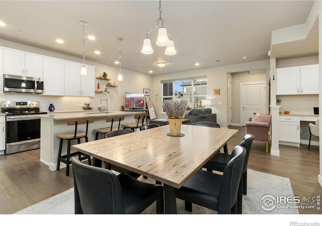 dining area featuring sink and dark hardwood / wood-style floors