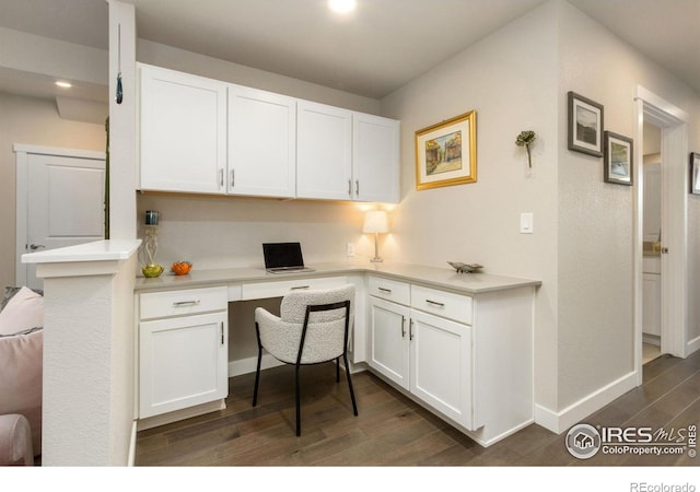 office with baseboards, dark wood-type flooring, built in desk, and recessed lighting