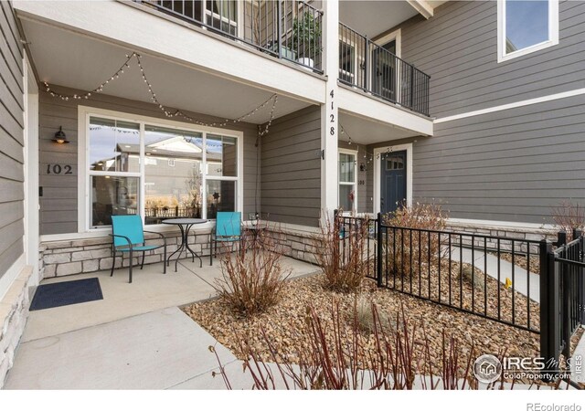 view of patio with a balcony and fence