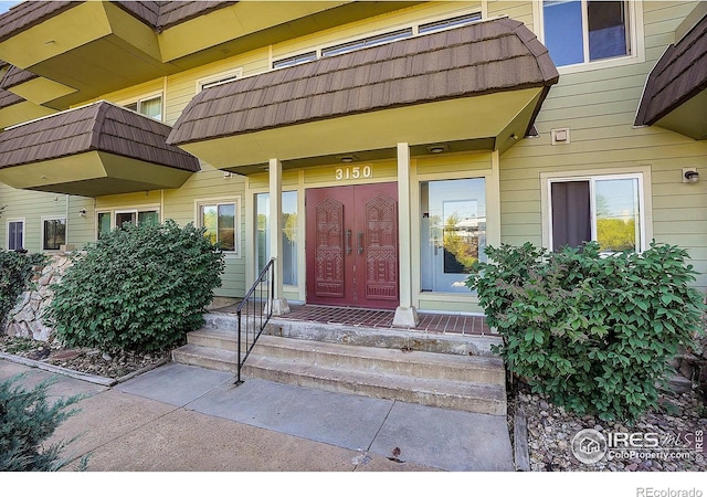 property entrance with a tiled roof and mansard roof