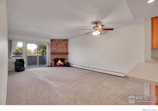 unfurnished living room with a textured ceiling, a baseboard heating unit, a fireplace, a ceiling fan, and carpet