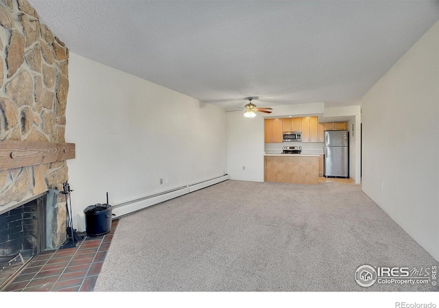 unfurnished living room with a baseboard heating unit, a ceiling fan, carpet flooring, a stone fireplace, and a textured ceiling