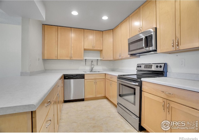 kitchen with recessed lighting, light countertops, light brown cabinetry, appliances with stainless steel finishes, and a sink