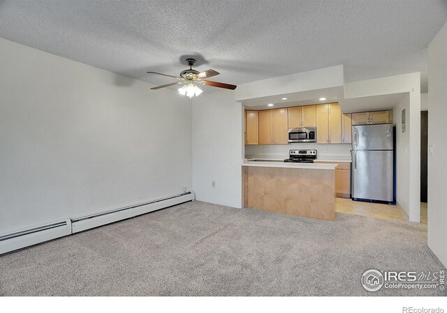 kitchen with a baseboard heating unit, stainless steel appliances, light carpet, light countertops, and light brown cabinetry