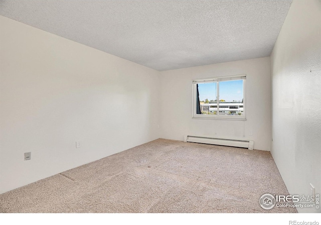 carpeted spare room featuring a baseboard heating unit and a textured ceiling