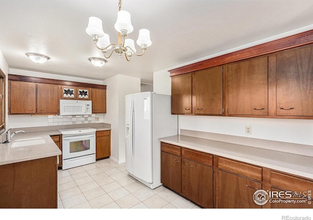 kitchen featuring sink, a chandelier, pendant lighting, white appliances, and light tile patterned floors