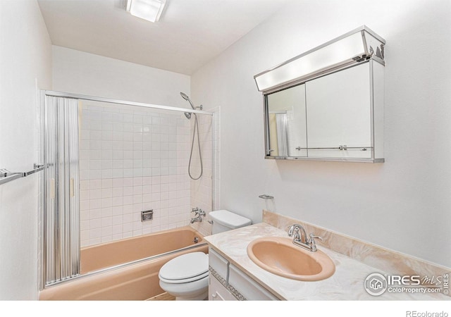 full bathroom with vanity, tiled shower / bath combo, and toilet