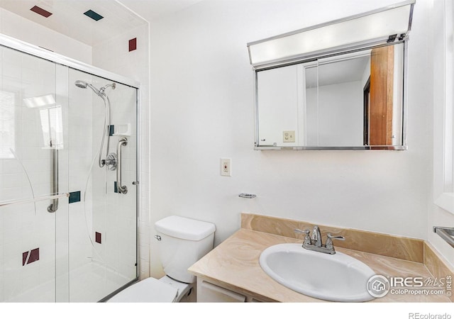 bathroom with toilet, vanity, and walk in shower