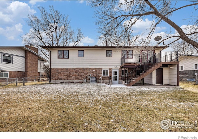 back of house with a deck, central AC unit, and a lawn