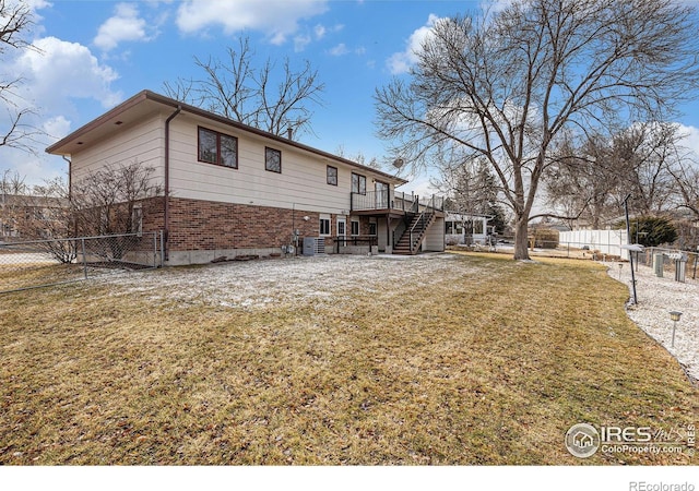 rear view of property featuring a lawn and a deck