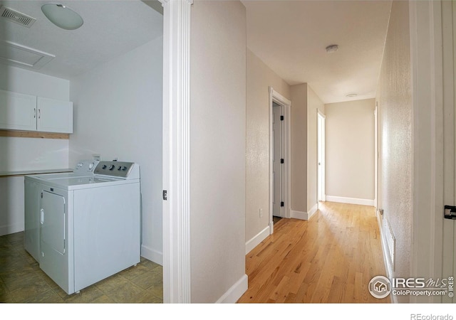 washroom with cabinets, light wood-type flooring, and independent washer and dryer