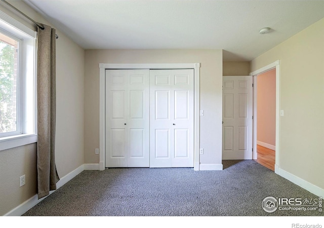 unfurnished bedroom with carpet and a closet