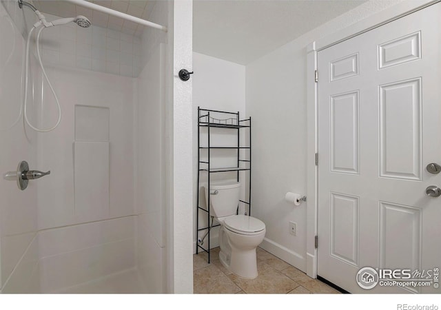 bathroom with tile patterned flooring, toilet, and walk in shower