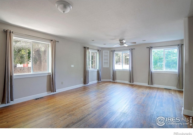 unfurnished room featuring a textured ceiling, light hardwood / wood-style floors, and ceiling fan