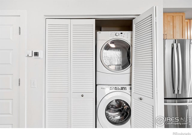 clothes washing area featuring stacked washer / drying machine