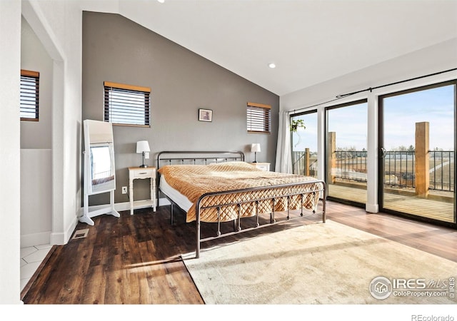 bedroom featuring access to exterior, multiple windows, and wood finished floors